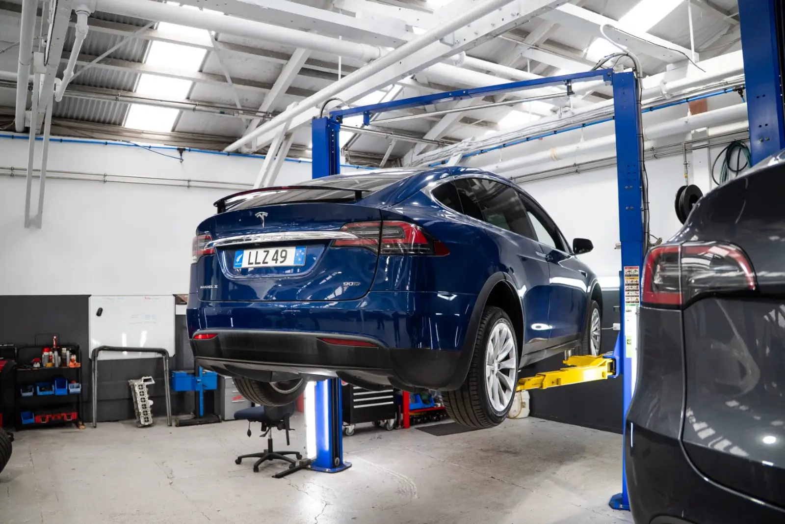Rear of a Tesla Model X raised on the hoist